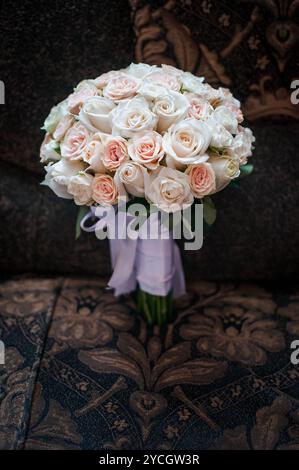 Eleganter Brautstrauß aus weißen und rosa Rosen mit zartem Band. Stockfoto