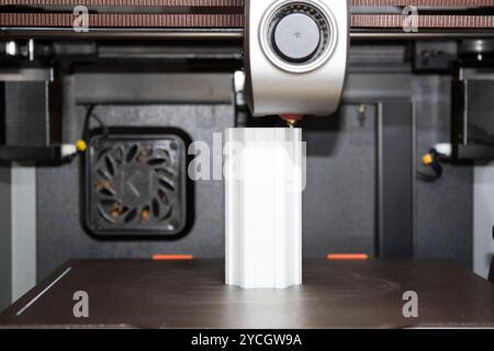 3D-Druckmaschine, die aus einer digitalen Datei ein dreidimensionales weißes Objekt herstellt. Der 3D-Drucker kann sehr komplexe Formen oder Geometrien erzeugen. Stockfoto