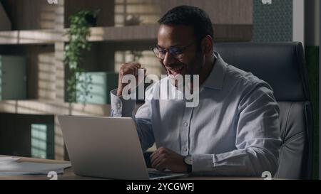 Überglückter indischer Geschäftsmann American man Laptop Wette begeistert von unglaublichen guten Nachrichten glücklicher emotionaler Executive Sieg Computergewinn erreichen Stockfoto