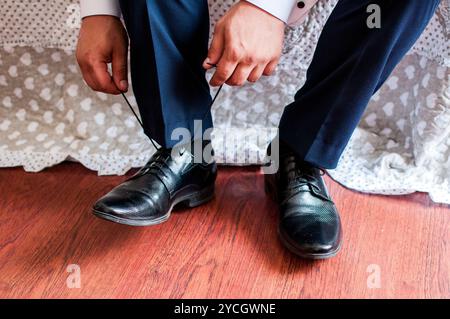 Eleganter Bräutigam, der sich auf den Hochzeitstag in klassischer Kleidung vorbereitet. Stockfoto