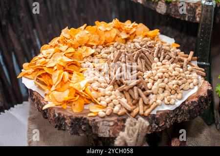 Lebendige Auswahl an knusprigen Snacks auf rustikalen Holzplatten. Stockfoto