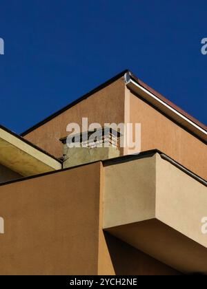 Gebäudearchitektur und Dachterrasse vor blauem Himmel: Low Angle Perspektive. Städtische Symmetrie. Stockfoto