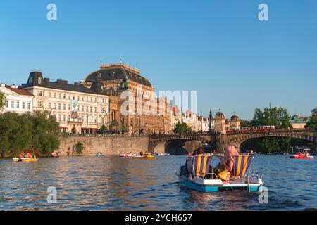 Prag, Tschechische Republik - 19. Mai 2015: Touristen genießen einen sonnigen Sommertag, fahren mit dem Tretboot auf der Moldau mit dem Nationaltheater und Stockfoto