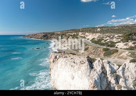 Touristen, die auf einer Klippe stehen, genießen den Panoramablick auf den Felsen von Aphrodite (Petra tou Romiou), ein beliebtes Touristenziel in Zypern. Paphos D Stockfoto