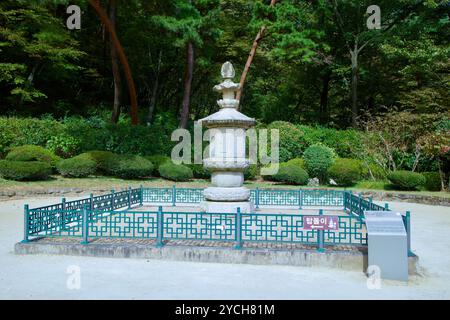 Ulsan, Südkorea - 22. Oktober 2023: Eine ruhige Steinpagode ist umgeben von Grün und einem traditionellen Zaun und schafft eine friedliche Atmosphäre Stockfoto