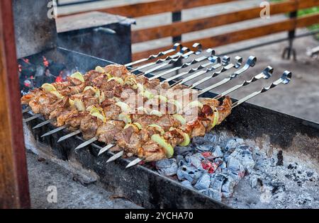 Saftige Scheiben von Fleisch mit Soße vorbereiten auf Feuer Stockfoto