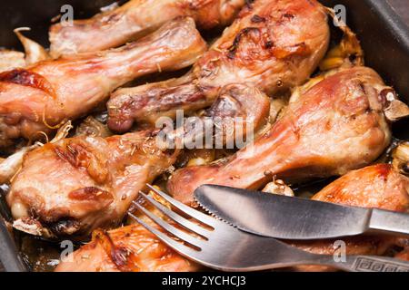 Gebackene Hähnchenschenkel in Tablett auf schwarzem Holz Stockfoto