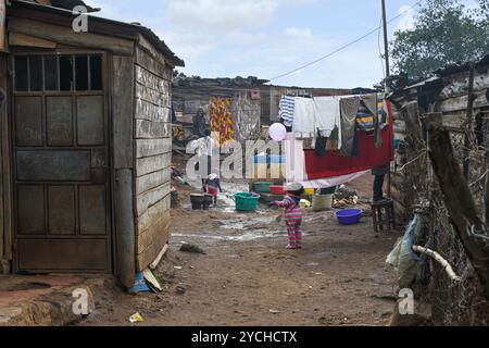 NAIROBI SLUM KIBERA, KENIA, AFRIKA - 18. NOVEMBER 2022: Slumbewohner waschen und hängen Wäsche auf der Straße auf. Nairobi, Kenia Stockfoto