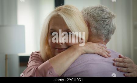 Glückliches reifes kaukasisches liebendes Ehepaar Mann Frau Ehemann Ehefrau genießt die Verbindung zu Hause Senioren pensionierte Großeltern umarmen sich kuscheln Stockfoto