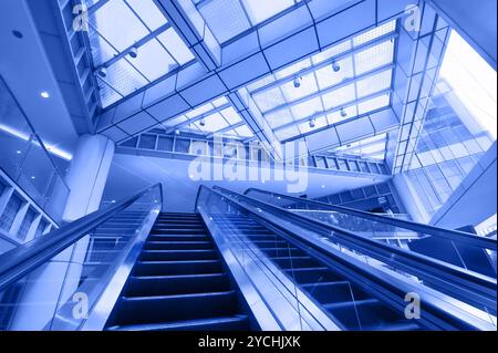 Rolltreppe im modernen Business Center. Blaue Tonung i Stockfoto