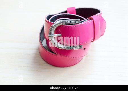 Ein rosa Damen Gürtel auf einem hölzernen Hintergrund Stockfoto
