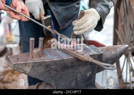 Schmied schmiedet ein heiße Hufeisen auf dem Amboss Stockfoto