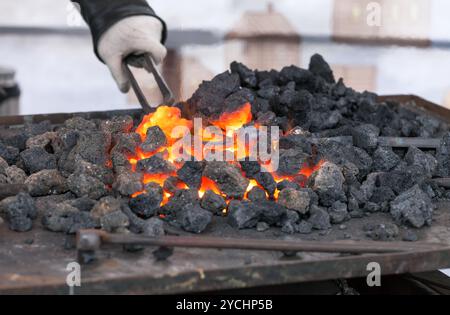 Schmied schmiedet ein glühendes Eisen in der Schmiede Stockfoto