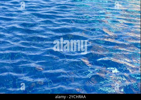 Die ruhige Oberfläche des Wassers kräuselt sich sanft und spiegelt das Sonnenlicht wider, während ein bezauberndes blaues Mosaik entsteht, das die Sinne verzaubert. Stockfoto