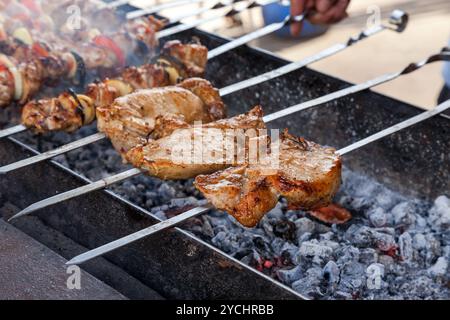 Saftige Scheiben von Fleisch mit Soße vorbereiten auf Feuer Stockfoto