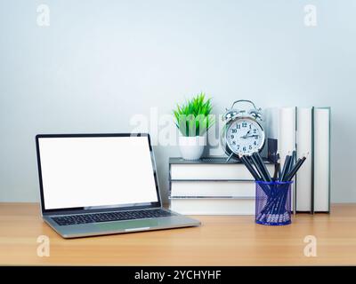 Platz zum Kopieren des Textes. Laptop mit leerem Bildschirm auf weißem Tisch und Bürobedarf auf hölzernem Hintergrund. Arbeitsbereich und Kopierbereich. Schreibtisch mit aus Stockfoto
