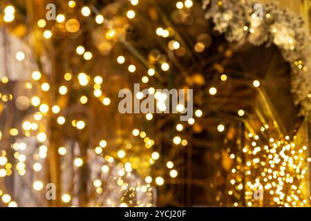 Ein verschwommener Hintergrund mit warmen, leuchtenden Weihnachtslichtern sorgt für eine festliche Atmosphäre. Bokeh-Hintergrund von Feenlichtern in einer Londoner Arkade. Stockfoto