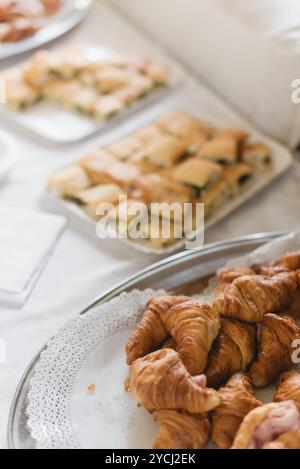 Ein wunderschön gestalteter Tisch mit eleganten Vorspeisen für eine Hochzeitsfeier, einschließlich Fingerfood wie Mini-Sandwiches, Scones, Käseplatten, usw. Stockfoto