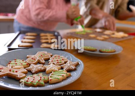 weihnachtskekse dekorieren multirassisches Seniorenpaar zu Hause und genießen festliches Weihnachtsbacken Stockfoto