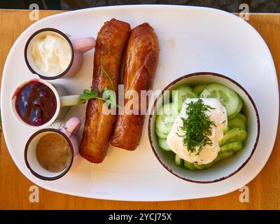 Kartoffelwurst mit Sauerrahm und eingelegter Gurke Stockfoto