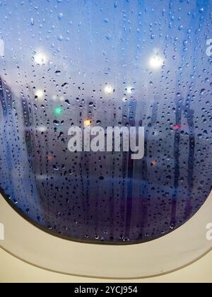 Wasser tropft auf das Fenster eines Flugzeugs Stockfoto