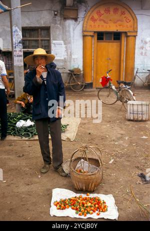 Provinz Anhui, China Gemeinde Liufu ländliches Leben ländliche Armut. Freier Betrieb ein Mann, der auf dem täglichen Dorfmarkt hausgemachte Erdbeeren verkauft. Juni 1998 1990: HOMER SYKES Stockfoto