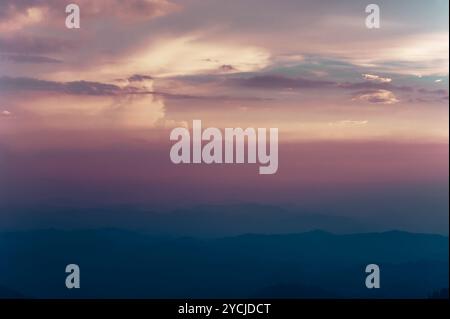 Schönen Sonnenuntergang Himmel Farben mit dramatische Wolken und nebligen Bergen Silhouette. Süd-Indien Landschaft. Munnar, Kerala, Indien Stockfoto