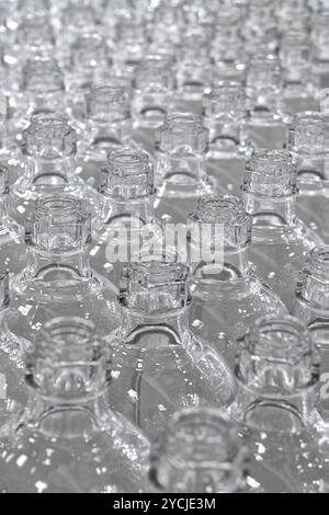 Viele leere saubere Glasflaschen. Nahaufnahme, selektiver Fokus, abstrakter Hintergrund für Recycling oder Verpackung. Stockfoto