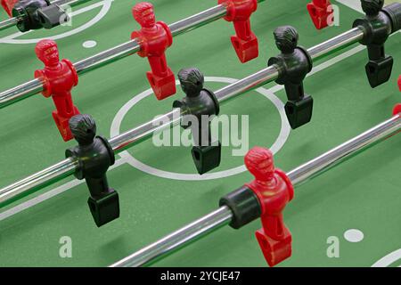 Kicker oder Kicker, Tischfußball oder Fußballspiel, Plastikfiguren auf einem grünen Feld. Nahaufnahme, abstrakter Unterhaltungshintergrund. Stockfoto