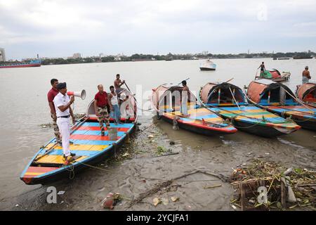 Zyklon-Dana-Alarm in Kalkutta, Indien Ein Mitglied der Verkehrspolizei auf dem Fluss Kalkutta appelliert mit einem Megaphon an die Menschen, an einen sichereren Ort vor Zyklon Dana zu ziehen, während einer Patrouille auf dem Fluss Ganges in Kalkutta, Indien, am 23. Oktober 2024. Das Regional Meteorological Centre Kolkata IMD hat prognostiziert, dass der Zyklon Dana in den nächsten drei Tagen starke Regenfälle in verschiedenen Bezirken in Odischa und Westbengalen bringen wird. Der Wirbelsturm soll am 25. Oktober zwischen dem Bhitarkanika-Nationalpark und dem Hafen von Dhamra in Odisha an Land kommen, wobei die Windgeschwindigkeiten bis zu 120 Kilometer betragen können Stockfoto