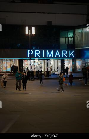 Straßenszene mit einigen Leuten im Primark am Alexanderplatz in Berlin am Abend Stockfoto