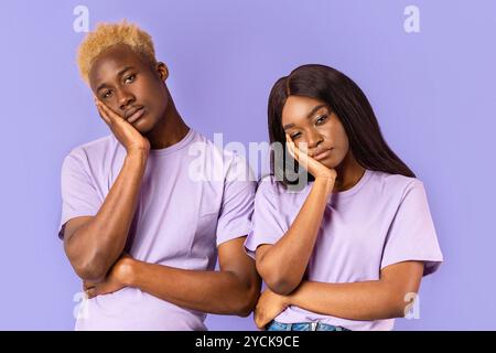 Gelangweilt afroamerikanischen Paar mit stumpfen Gesichtsausdrücke auf Farbhintergrund Stockfoto