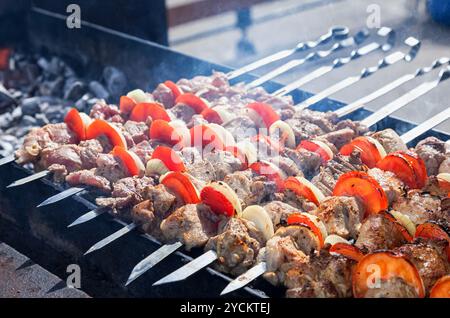 Saftige Scheiben von Fleisch mit Soße vorbereiten auf Kohlen Stockfoto