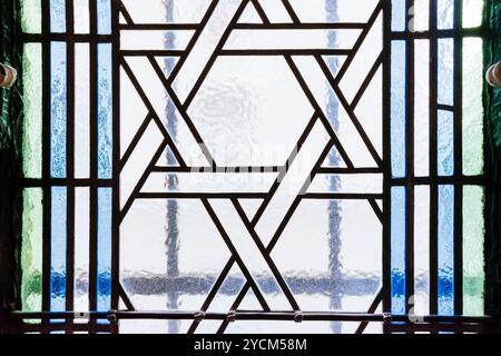 Buntglasfenster mit Ornament von Magen David, Hexagramm. Die Zeremonienhalle der Prager Jüdischen Begräbnisgesellschaft wurde für den letzten Dienst an der gebaut Stockfoto