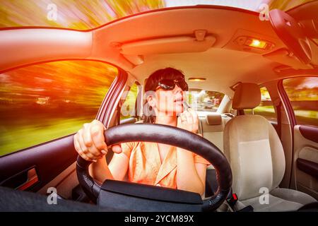 Frauen machen das Auto, nicht die Blicke auf der Straße, die Schaffung einer Notsituation Lippen am Steuer. Stockfoto