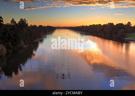 Sonnenaufgang über dem Nepean River in Penrith NSW, Australien. Kayayers Ruder wackeln die Wasserreflexionen während des Morgendämmerns Stockfoto