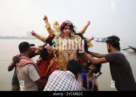 Durga Puja Festival in Kalkutta, Indien Indianer tauchen ein Idol der hinduistischen Göttin Durga in den Ganges als Ritual während des Durga Puja Festivals in Kalkutta, Indien, am 13. Oktober 2024 ein. Durga Puja ist ein bedeutendes Hindu-Festival in Indien, das den Sieg der Göttin Durga über den Dämon Mahishasura feiert und den Triumph des Guten über das Böse symbolisiert. Es umfasst lebhafte Rituale, mit Großpandalen geschmückte Strukturen, kulturelle Darbietungen und Prozessionen, insbesondere in Westbengalen, Assam und anderen ostindischen staaten. Kalkutta Indien Copyright: XMatrixxImagesx/xRupakxDexChowdhurix Stockfoto