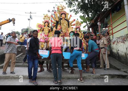 Durga Puja Festival in Kalkutta, Indien Indianer tragen am 13. Oktober 2024 ein Idol der hinduistischen Göttin Durga, um es als Ritual in den Ganges einzutauchen. Durga Puja ist ein bedeutendes Hindu-Festival in Indien, das den Sieg der Göttin Durga über den Dämon Mahishasura feiert und den Triumph des Guten über das Böse symbolisiert. Es umfasst lebhafte Rituale, mit Großpandalen geschmückte Strukturen, kulturelle Darbietungen und Prozessionen, insbesondere in Westbengalen, Assam und anderen ostindischen staaten. Kalkutta Indien Copyright: XMatrixxImagesx/xRupakxDexChowdhurix Stockfoto