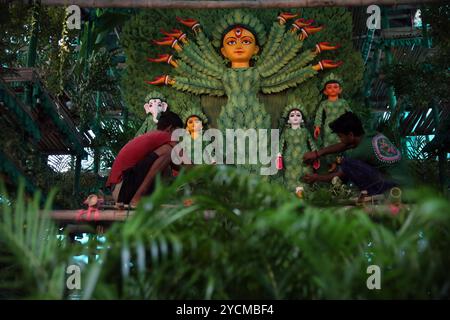 Durga Puja Festival in Kalkutta, Indien indische Handwerker schmücken ein Idol der hinduistischen Göttin Durga mit achttausend natürlichen Pflanzen, um das Bewusstsein für die globale Entwaldung, den Klimawandel und die Bedeutung von Bäumen an einem pandalengeschmückten Gebäude zu schärfen, vor dem Durga Puja Festival in Kalkutta, Indien, am 27. September 2024. Durga Puja ist ein bedeutendes Hindu-Festival in Indien, das den Sieg der Göttin Durga über den Dämon Mahishasura feiert und den Triumph des Guten über das Böse symbolisiert. Es umfasst lebendige Rituale, mit Großpandalen geschmückte Strukturen, kulturelle Darbietungen und Prozessionen, Parti Stockfoto