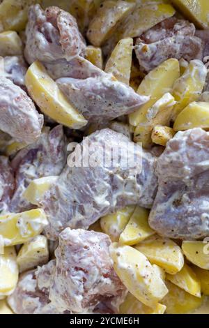 Hühnerscheiben werden vor dem Kochen mit Kartoffeln mariniert, Nahaufnahme im Vollformat Stockfoto