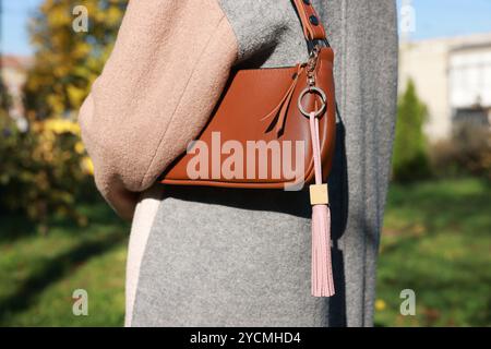 Frau mit rosa Leder Schlüsselanhänger an ihrer Tasche draußen, Nahaufnahme Stockfoto