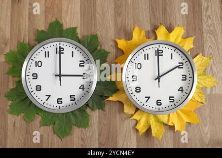 Zwei Uhren: Eine zeigt drei Uhr, die andere zwei Uhr. Symbolisiert den Wechsel von Sommer- zu Winterzeit. Stockfoto