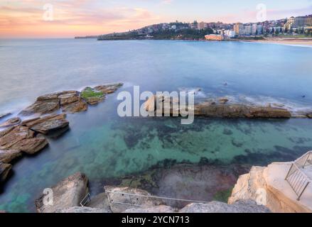 Der Blick von der Landzunge hinunter zum Giles Baths Felspool bei Coogee bei einer Flut. Bei Ebbe wird das Felsregal unten an der Treppe freigelegt. Stockfoto