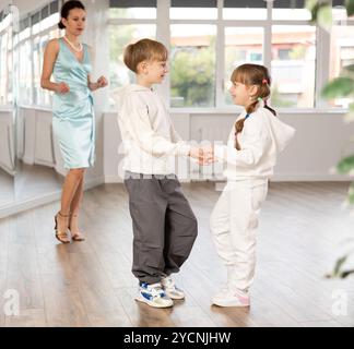 Tween Junge und Mädchen, die Walzer zu zweit in der Tanzhalle spielen Stockfoto