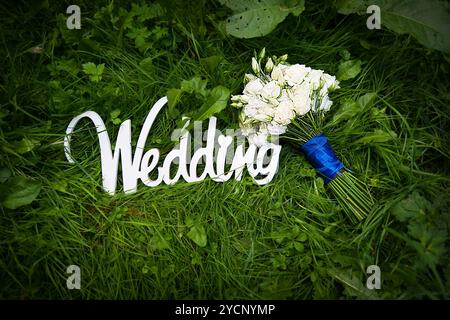 Hochzeitsbriefe mit weißen Blumen auf Gras Stockfoto