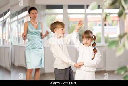 Tween Junge und Mädchen, die Walzer zu zweit in der Tanzhalle spielen Stockfoto