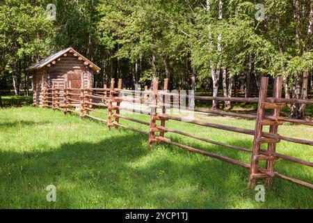 Holzzaun mit kleinen Holzhaus in Landschaft Stockfoto