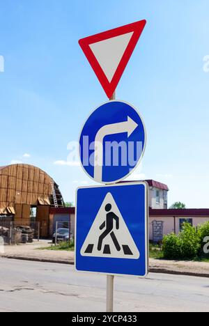 Triangular, Runde und quadratische Verkehrszeichen vor blauem Himmel Stockfoto