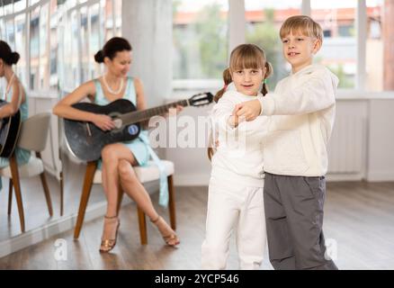 Jugendliche Tänzer üben mit Gitarrenbegleitung im Choreographiestudio Stockfoto