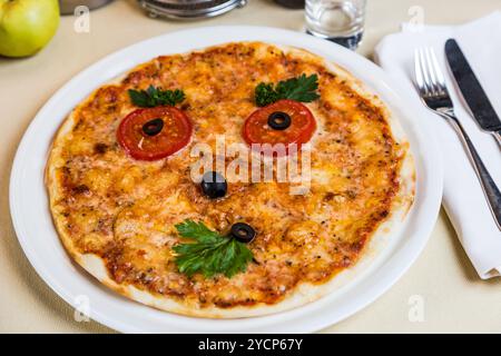 Restourant Servierplatte für Kindermenüs - Pizza mit Gesicht Stockfoto